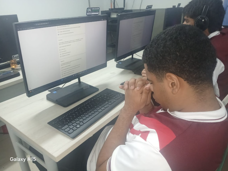 Estudiante concentrado respondiendo el test final en un computador